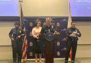 LAPD Chief Michel Moore (center) speaks to media about the department's new ability to file traffic reports online. 