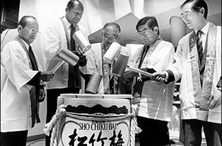 Mayor Bradley and four Japanese men as they break open a drum of sake.
