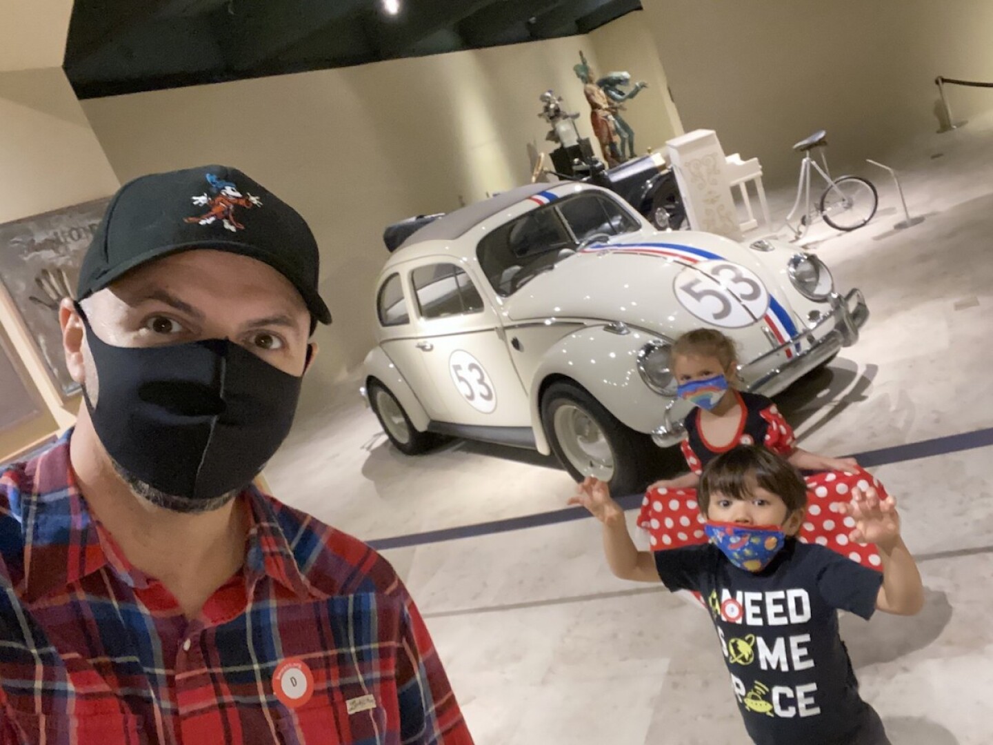 two children and an adult in front of Herbie the Love Bug