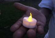 One of the over 100 people gathered at the vigil holds a candle in honor of the victims of the El Paso shooting. 
