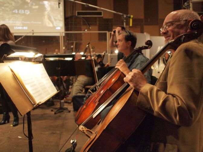 Two cellists rest during a break while recording the score for Disney's John Carter