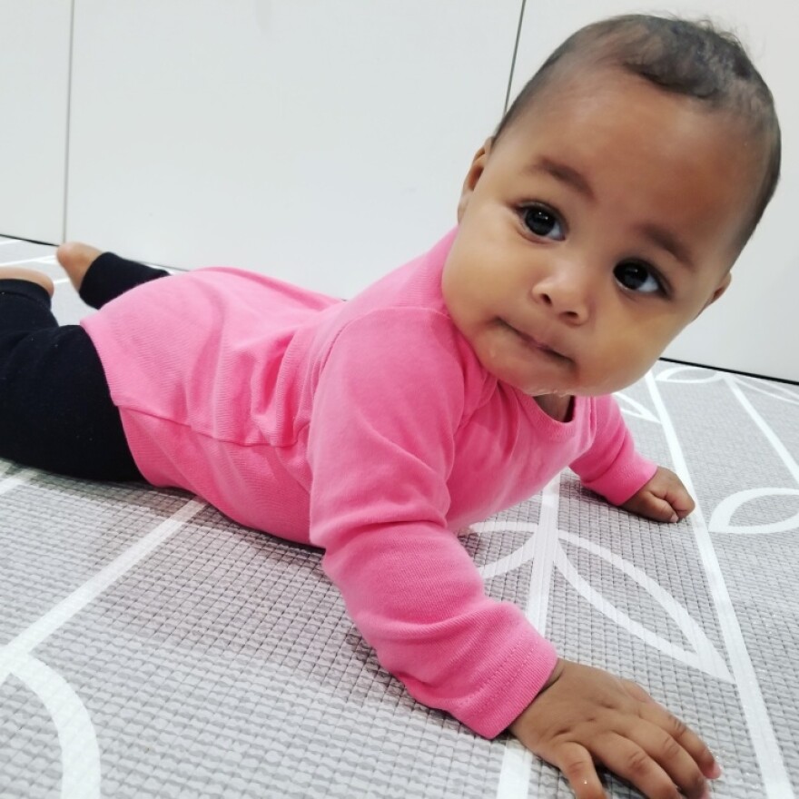 A small brown baby lies on its tummy.