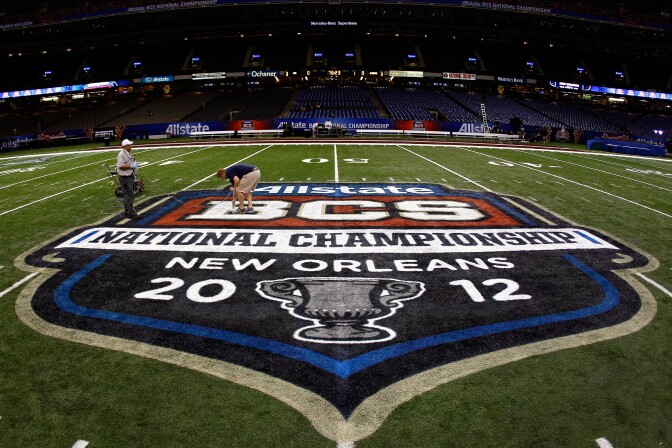 NEW ORLEANS, LA - JANUARY 08:  Grounds crew workers paint the Allstate BCS Championship logo on the field at the Mercedes-Benz Superdome on January 8, 2012 in New Orleans, Louisiana.  (Photo by Michael Heiman/Getty Images)