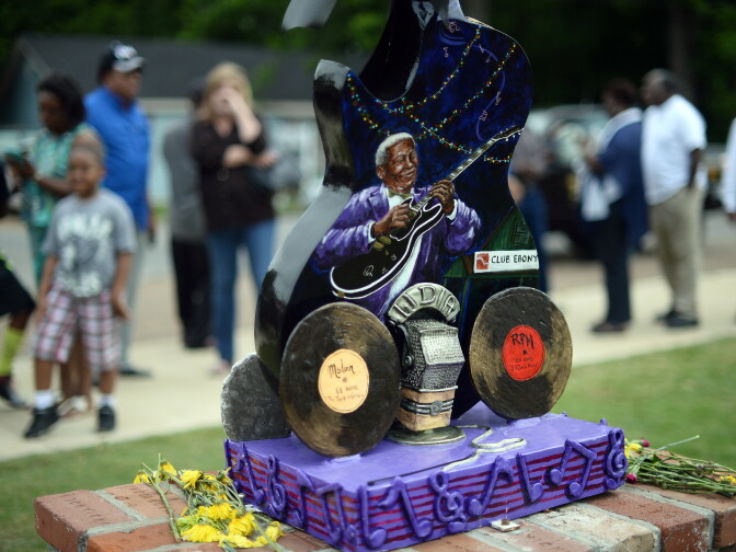 An image of B.B. King playing guitar as is seen as mourners line up outside the B.B. King Museum and Delta Interpretive Center in Indianola, Mississippi, on May 29, 2015 to attend a public wake for the blues legend. Hundreds of fans gathered to pay their respect to King, who died on May 14 at the age of 89 in Las Vegas.