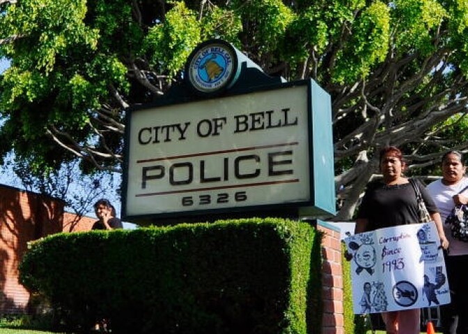 Residents of the City of Bell, holding protest placards are calling for the ouster of city officials arrive for the start of council meeting on July 26, 2010 in Bell, California.