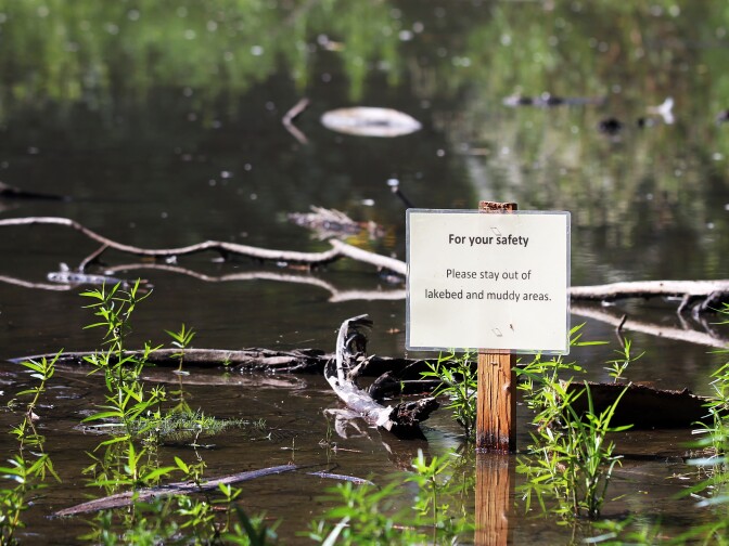 A sign warns visitors to avoid walking in Baldwin Lake inside the Los Angeles County Arboretum & Botanic Garden in Arcadia on Tuesday morning, Aug. 23, 2016.