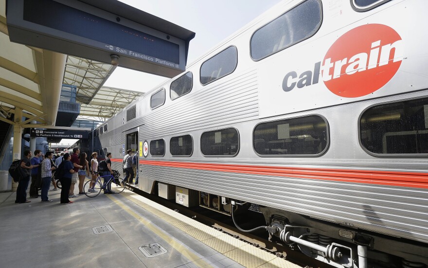 FILE  - In this July 1, 2013, file photo, commuters board a Caltrain train at the Caltrain and Bay Area Rapid Transit station in Millbrae, Calif. The Federal Transit Administration is delaying a decision on whether to approve a $650 million federal grant for electrification of a San Francisco Bay Area train system that would also help California's high-speed rail project. Congressional Republicans had pushed the administration to reject the application from Caltrain. (AP Photo/Jeff Chiu, File)