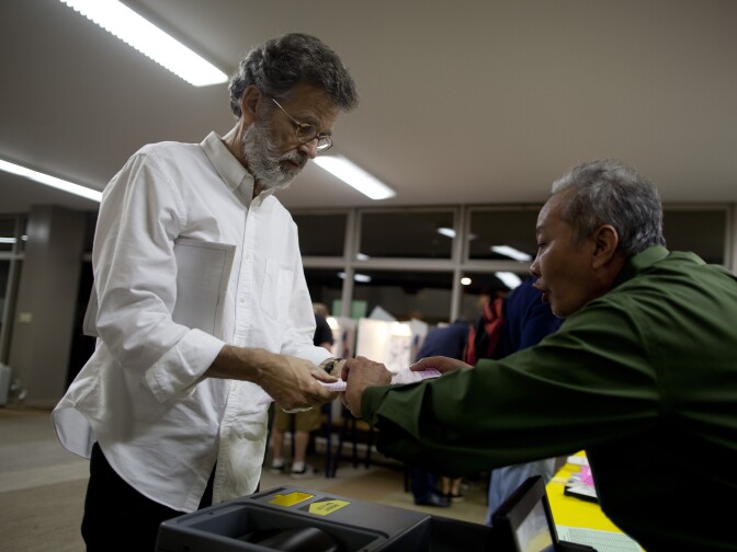 Polls inspector Sweety Chap helps voter Stephen Nathan insert his ballot into the ballot box at the First Methodist Church in Santa Monica.