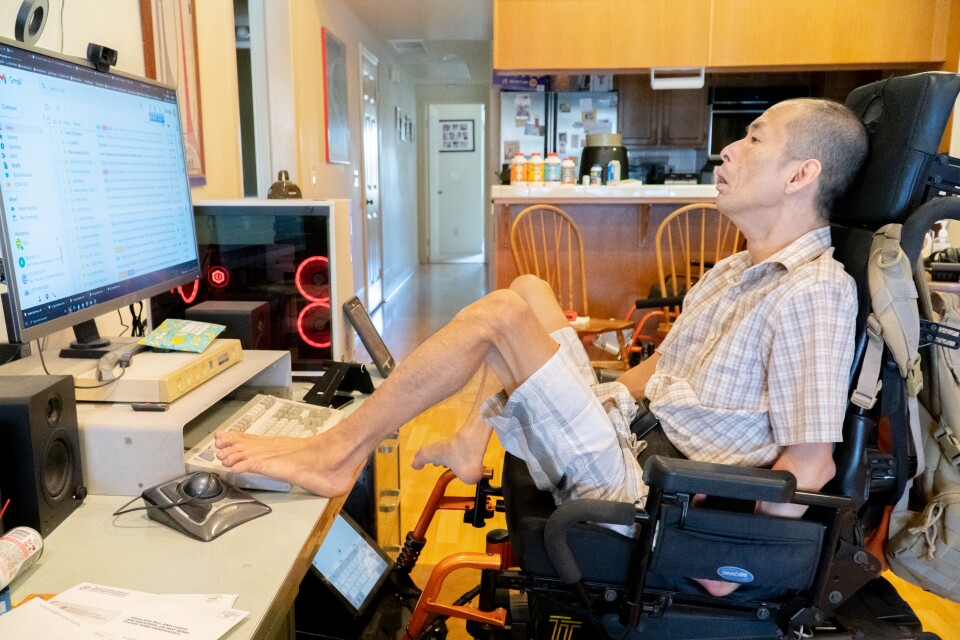 Tim Jin at his computer, using his feet to type.