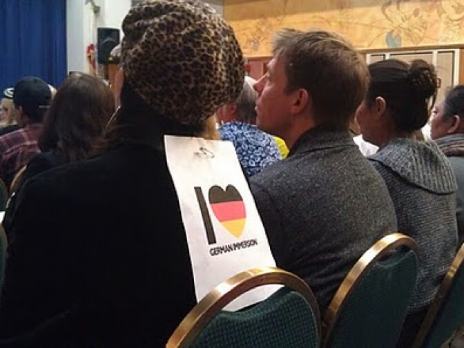 A Franklin Elementary School parent wears a sign that says "I love German Immersion" at a Tuesday night meeting in Glendale.