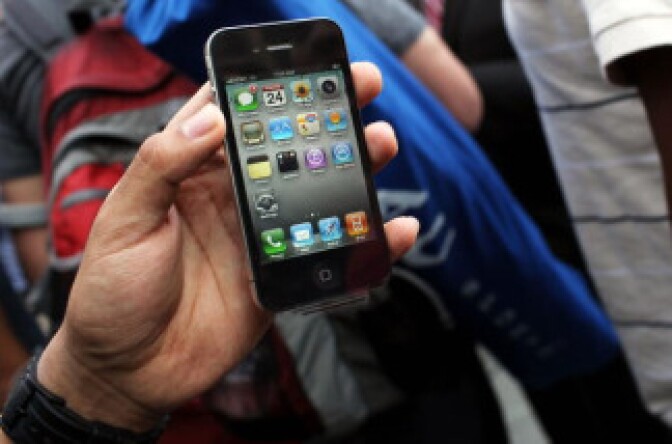 One of the first customers in line at the flagship Apple Store on Fifth Avenue displays his new iPhone 4