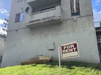 A "for rent" sign hangs near a discarded mattresses outside an apartment building in the city of Los Angeles. 