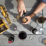 An array of beer bottles sit on a picnic table.