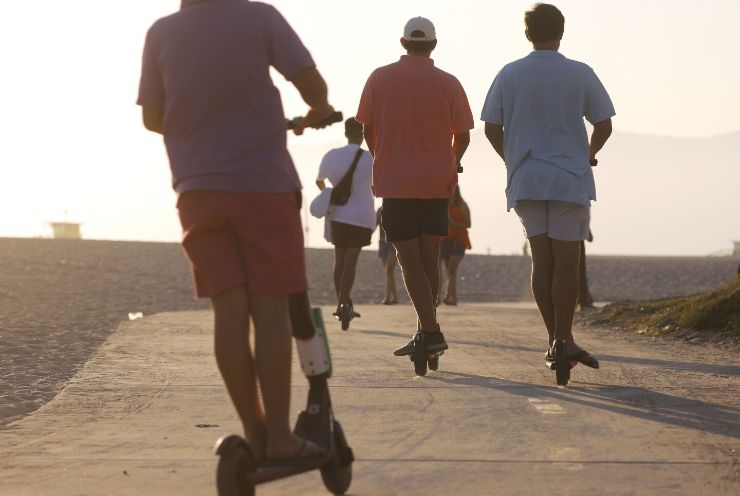 LOS ANGELES, CA - AUGUST 13:  People ride shared dockless electric scooters along Venice Beach on August 13, 2018 in Los Angeles, California. Some city residents complain the controversial e-scooters are dangerous for pedestrians and sometimes clog sidewalks. A Los Angeles Councilmember has proposed a ban on the scooters until regulations on the scooters can be worked out. (Photo by Mario Tama/Getty Images)