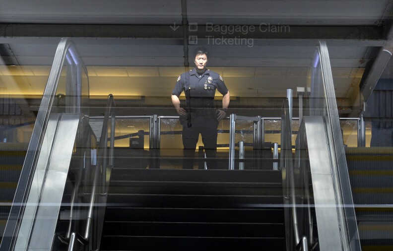 LOS ANGELES, NOVEMBER 2: A Los Angeles Airport Police officer stands in front of Terminal 3 security screeners, the site of shooting scene, after law enforcement official completed their investigation and prepare to re-open the terminal at Los Angeles International Airport November 2, 2013 in Los Angeles, California. The airport is almost back to normal operations a day after a man pulled an assault rifle and shot his way through security at Terminal 3, killing one Transportation Security Administration worker and wounding several others. Federal officials identified the alleged gunman as Paul Ciancia, 23, of New Jersey. (Photo by Kevork Djansezian/Getty Images)