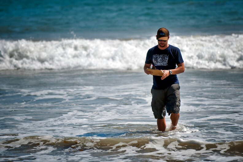 UCSB graduate student Nick Schooler measures wave frequency at a Malibu beach.