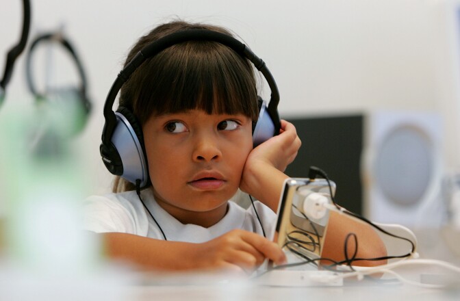 Six-year-old Emma Cordell listens to a new iPod on display at the Apple Store in San Francisco, California.