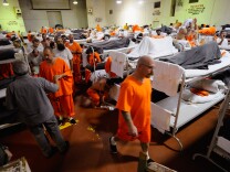 Inmates at Chino State Prison walk past their bunk beds in a gymnasium that was modified to house prisoners in this December 10, 2010 file photo taken in Chino, California. State and local authorities have since been recognized for their efforts to reduce their jail and prison populations, but officials say L.A. County still has more inmates than it should. A grant announced on Tuesday, May 26, 2015, by the MacArthur Foundation puts the county in the running for further financial assistance in alleviating its overcrowded jails.