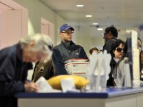 Aaron Pupa (C) waits in line at the customer counter at the Main Post Office on Dec. 19, 2011 in Chicago, Illinois.
