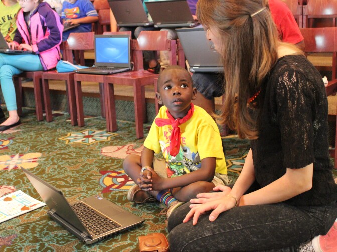 Children’s librarian Sylvia Aguiñaga works with 6-year-old Xander Baker on his project