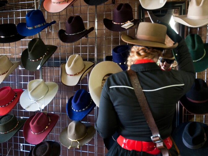 Collette Lash of Valencia tries on a new cowboy hat in Melody Ranch's Main Street, where actors like Clint Eastwood, Gene Autry, John Wayne, and Gregory Peck have worked on films.