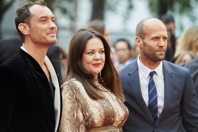 British actors Jude Law (L), US actress Melissa McCarthy (C), and British actor Jason Statham pose for photographs on the carpet as they arrive to attend the European premiere of the film 'Spy' in London on May 27, 2015.   AFP PHOTO / NIKLAS HALLE'N        (Photo credit should read NIKLAS HALLE'N/AFP/Getty Images)