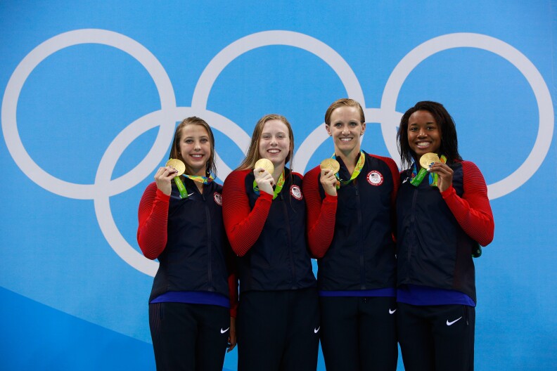 RIO DE JANEIRO, BRAZIL - AUGUST 13:  Gold medalists Kathleen Baker, Lilly King, Dana Vollmer, Simone Manuel of the United States celebrate on the podium during the medal ceremony for the Women's 4 x 100m Medley Relay Final on Day 8 of the Rio 2016 Olympic Games at the Olympic Aquatics Stadium on August 13, 2016 in Rio de Janeiro, Brazil.  (Photo by Adam Pretty/Getty Images)
