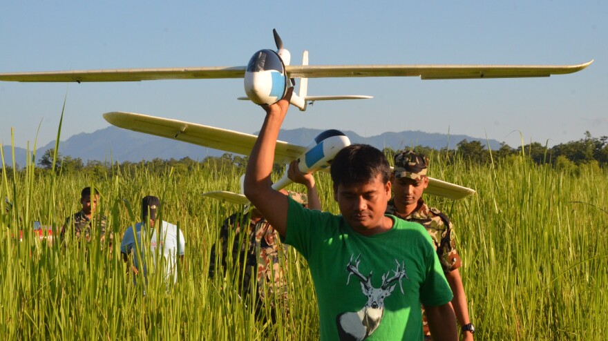 Park rangers and army personnel in Nepal carry unmanned aerial vehicles used to track wildlife and poaching activity. The drones, which can be programmed to fly automatically, are outfitted with cameras that relay live video to the ground.