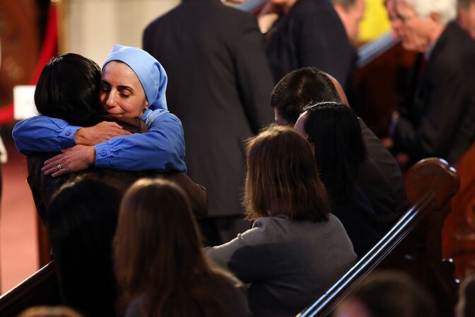 A nun hugs a woman at an interfaith prayer service for victims of the Boston Marathon attack titled "Healing Our City," and attended by President Barack Obama and First Lady Michelle Obama at the Cathedral of the Holy Cross on April 18, 2013 in Boston, Massachusetts.