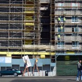 Pedestrians cross the street as construction workers work on the exterior of a commercial and residential building going up in Hollywood, California on January 22, 2014.  US housing starts dived almost 10 percent in December from a five-year high but maintained robust growth for the year as the housing market recovers,  government data showed last week, as new residential construction fell to a seasonally adjusted annual rate of 999,900 in December. The full year 2013 data underlined the strength of last year's housing market recovery following the 2006 collapse of a price bubble. AFP PHOTO/Frederic J. BROWN        (Photo credit should read FREDERIC J. BROWN/AFP/Getty Images)