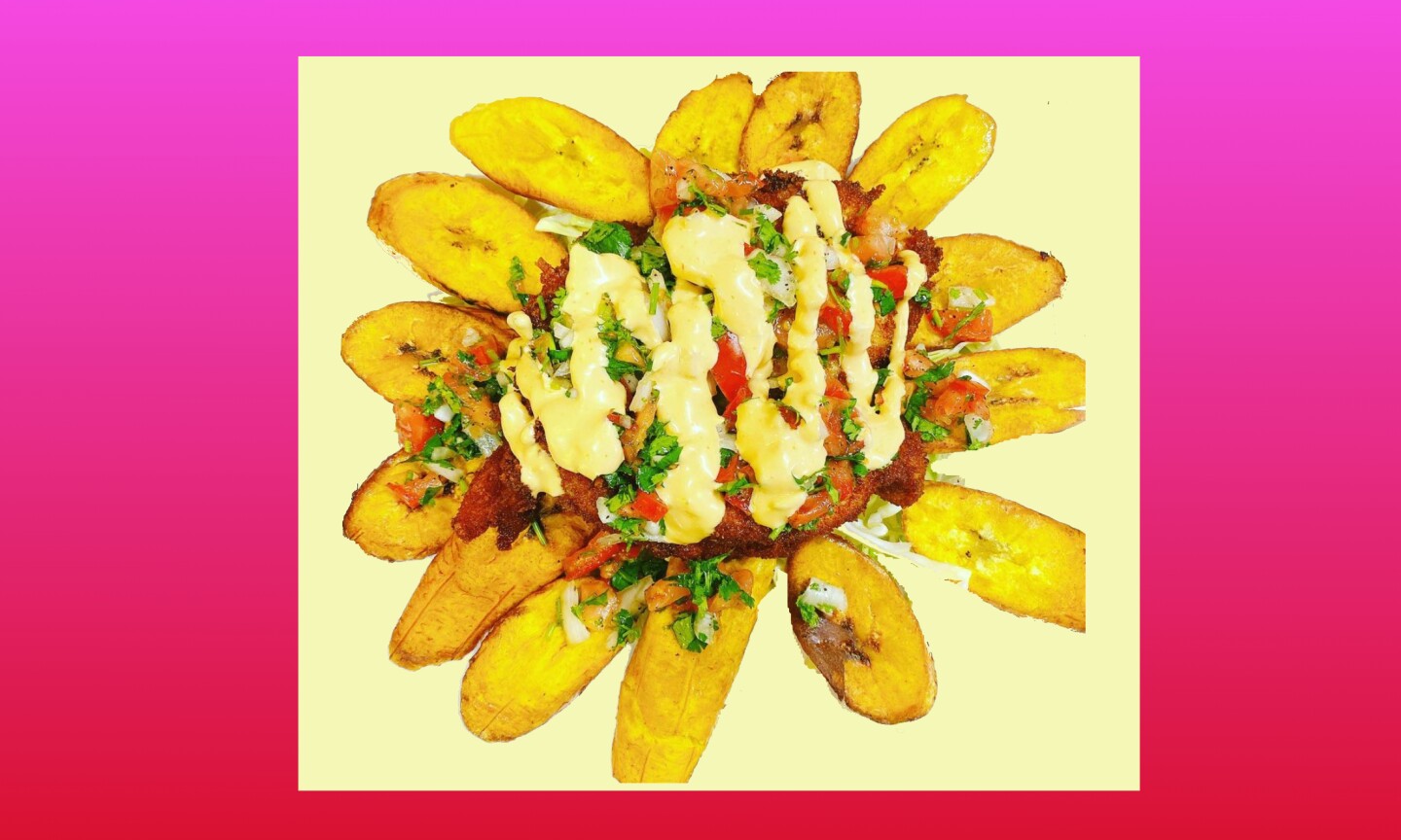 plantains are arranged in a wheel-like fashion and piled with a bunch of other food drizzled in a pale yellow cream sauce