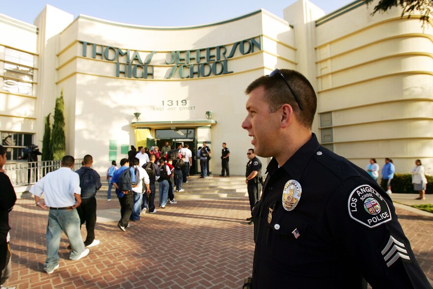 LOS ANGELES, CA - APRIL 21:  Los Angeles School Police Sgt. Robert Carlborn watches over students lining up to pass through a security check point in the aftermath of two apparent racially motivated student brawls at Thomas Jefferson High School April 21, 2005 in Los Angeles, California. A number of students suffered injuries this week while fleeing from a lunch period brawl involving about 200 Latino and African-American students, the second racially charged incident in less than a week. Stepped-up school police and Los Angeles police presence, strict regulation of clothing styles that could be associated with gangs, and a tightened school bell schedule that leaves little time to linger between classes are in effect to curb the violence.  (Photo by David McNew/Getty Images)