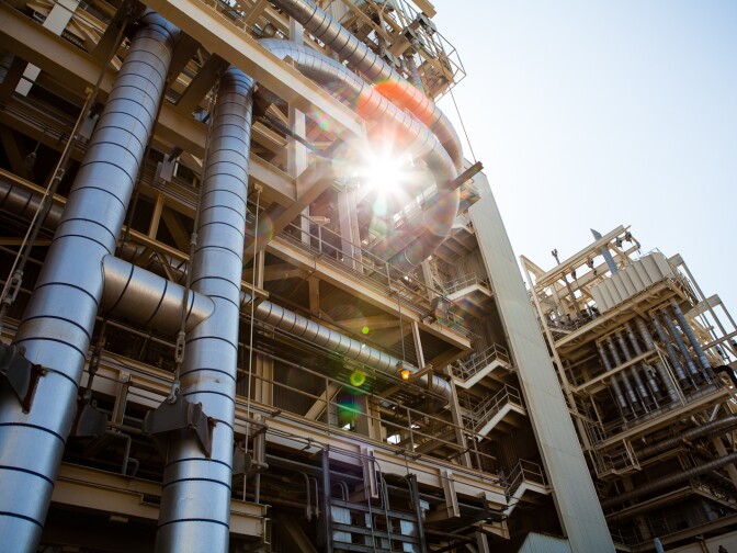 The sun shines through a maze of pipes at the AES Power Plant in Huntington Beach.