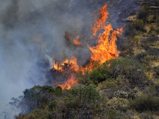 The Brand Fire burns down a hillside near Glendale Sunday afternoon. 