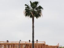 Construction workers are seen atop a builing of new apartments for sale in Alhambra, east of downtown Los Angeles, on March 23, 2012. Sales of new homes in the United States slipped for the second straight month in February but the median price of homes sold picked up sharply, according to the Commerce Department.    AFP PHOTO/Frederic J. BROWN (Photo credit should read FREDERIC J. BROWN/AFP/Getty Images)