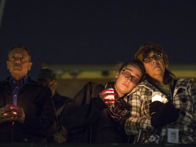 Attendees take part in a moment of silence as victims names are read aloud at the conclusion of a vigil at San Manuel Stadium in San Bernardino on Thursday night, Dec. 3, 2015 following a mass shooting that left 14 people dead and 21 injured on Wednesday at the Inland Regional Center.