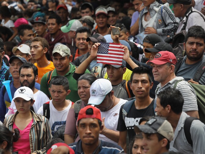 CIUDAD TECUN UMAN, GUATEMALA - OCTOBER 19:  Members of the migrant caravan push forward at a gate separating Guatemala from Mexico on October 19, 2018 in Ciudad Tecun Uman, Guatemala. The caravan of thousands of immigrants, most from Honduras, pushed open the gate on the Guatemalan side and crossed the bridge to Mexico but were then pushed back by Mexican riot police.  (Photo by John Moore/Getty Images)