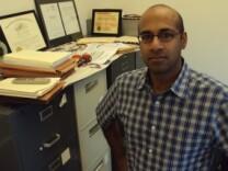 Ahilan Arulanantham is a lawyer with the ACLU in Los Angeles. He stands next to his file cabinets full of national security cases, many of which involve the Patriot Act.