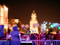 A DJ and the nighttime LA skyline on the Music Center plaza.