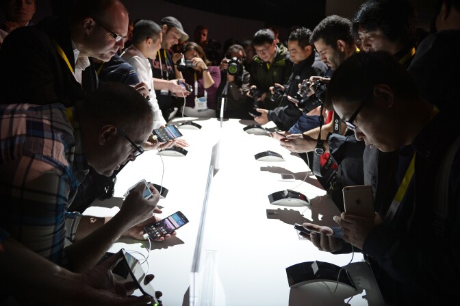 Attends get their first hands-on look at the new LG G Flex2 smart phone, at the LG press conference at 2015 Consumer Electronics Show in Las Vegas Nevada January 5, 2015.   AFP PHOTO / ROBYN BECK        (Photo credit should read ROBYN BECK/AFP/Getty Images)