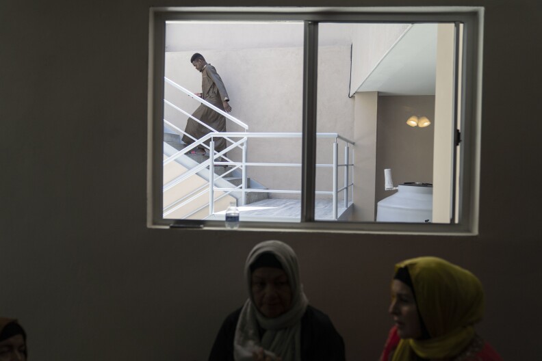 A migrant from Guinea, who is currently waiting for his family to arrive in Tijuana, walks up the stairs at the shelter.