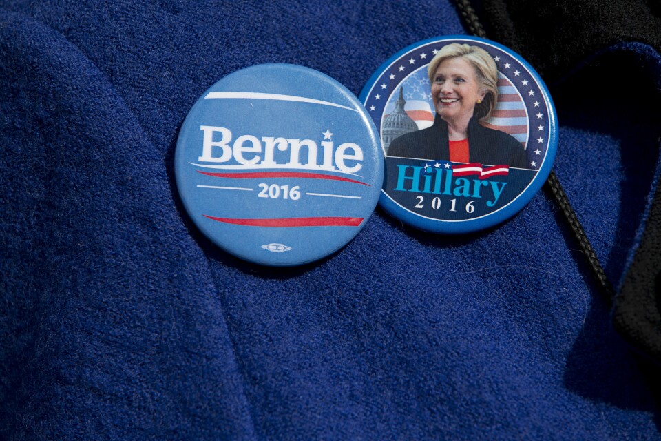 A demonstrator wears Democratic presidential candidate's Sen. Bernie Sanders, I-Vt., and Hillary Clinton buttons during a rally to condemn Republican presidential candidate Donald Trump's remarks about women and abortion, Thursday, March 31, 2016, in New York. (AP Photo/Mary Altaffer)
