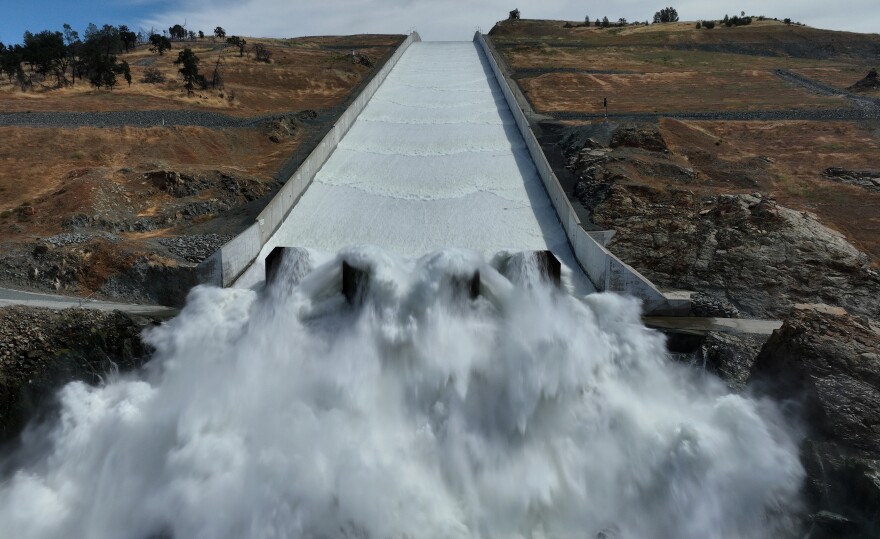 Water rushed down a long spillway flanked by earth.