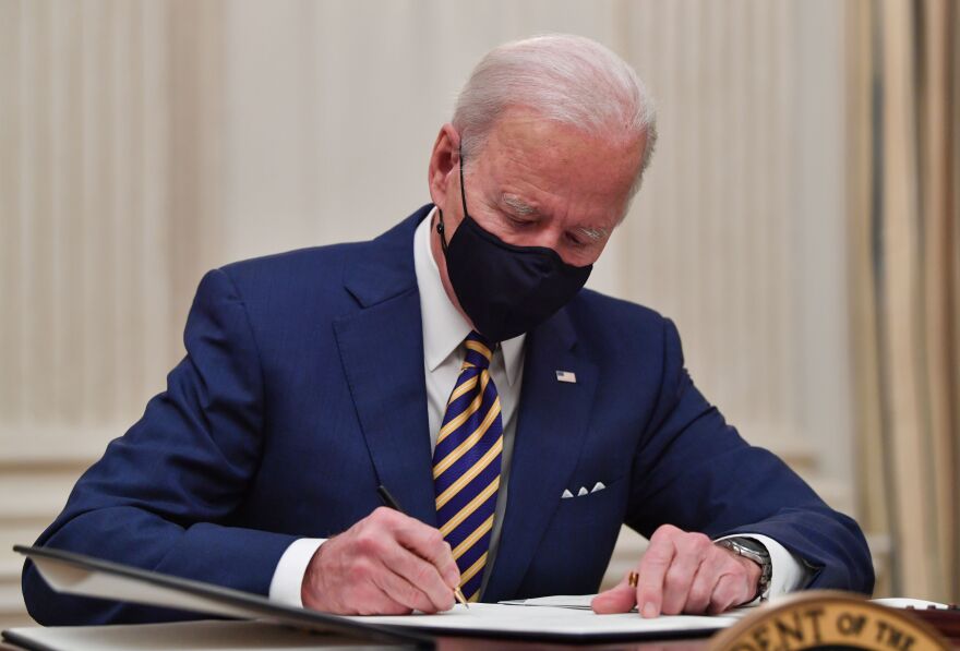 US President Joe Biden signs executive orders for economic relief to Covid-hit families and businesses in the State Dining Room of the White House in Washington, DC, on January 22, 2021. (Photo by Nicholas Kamm / AFP) (Photo by NICHOLAS KAMM/AFP via Getty Images)