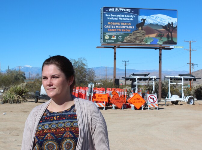 Breanne Dusastre of the 29 Palms Inn stands in front of a billboard she and other business leaders had installed along Highway 62 in Twentynine Palms, California, showing their support for national monuments and other protected lands. 