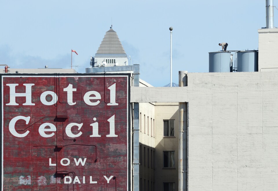 A worker stands on a water tank on the roof of the Hotel Cecil in Los Angeles, California on February 20, 2013. The body of 21-year-old Canadian tourist Elisa Lam was found in a water tank on the roof of the hotel three weeks after she went missing.
