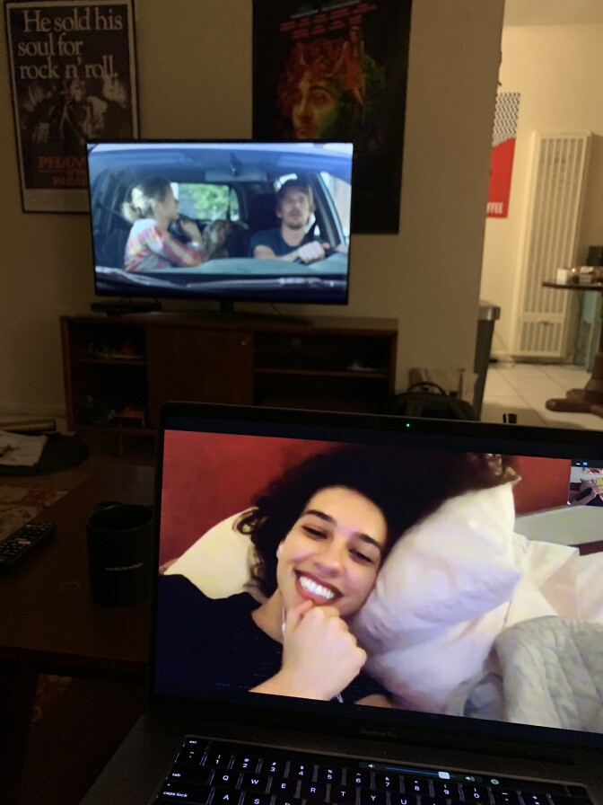 An image of a Latina, smiling as she talks to someone on Facetime 