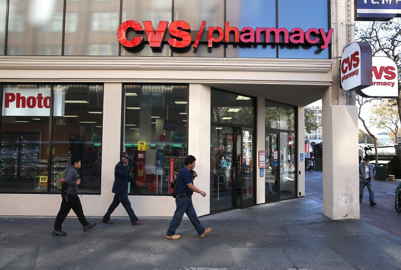 SAN FRANCISCO, CA - NOVEMBER 05:  Pedestrians walk by a CVS store on November 5, 2013 in San Francisco, California.  CVS Caremark reported a 25 percent surge in third-quarter earnings with profits of $1.25 billion, or $1.02 per share, compared to $1.01 billion, or 79 cents a share one year ago. (Photo by Justin Sullivan/Getty Images)