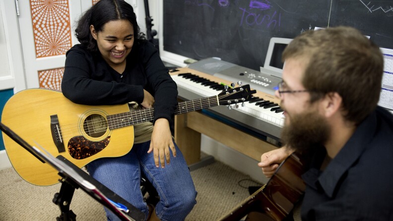 Tanzania Cantrell, 13, of Saginaw, Mich., jokes with her guitar instructor, Ryan Fitzgerald, during a lesson at Major Chords for Minors.