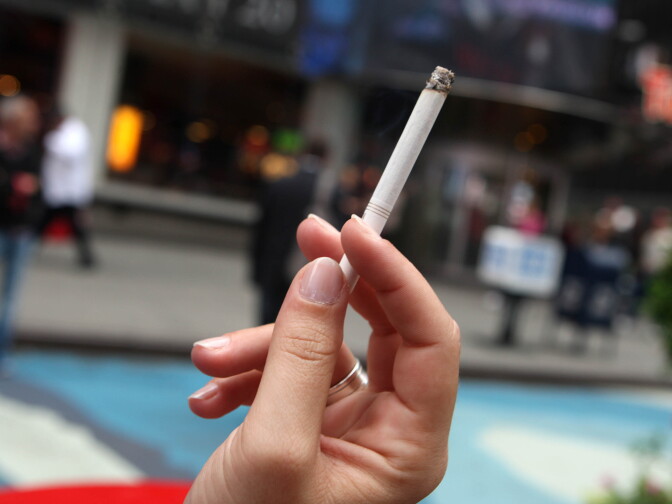A woman smokes a cigarette in the pedestrian plaza located in Times Square May 23, 2011 in New York City.